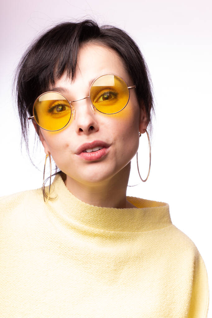 krásná dívka ve žlutých brýlích a žlutý svetr - Fotografie, Obrázek