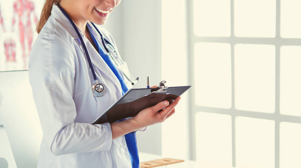 Nainen lääkäri seisoo kansio sairaalassa - Valokuva, kuva