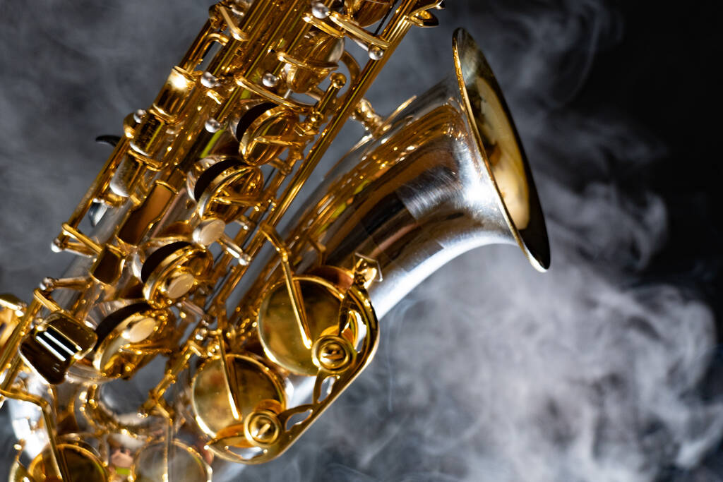 Saxophone alto brillant doré sur fond noir avec fumée. espace de copie
 - Photo, image