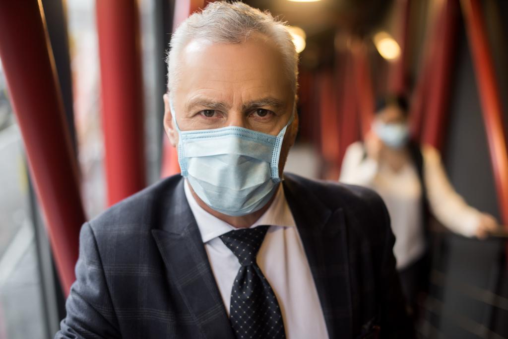 businessman in suit with medical mask looking at camera  - Photo, Image