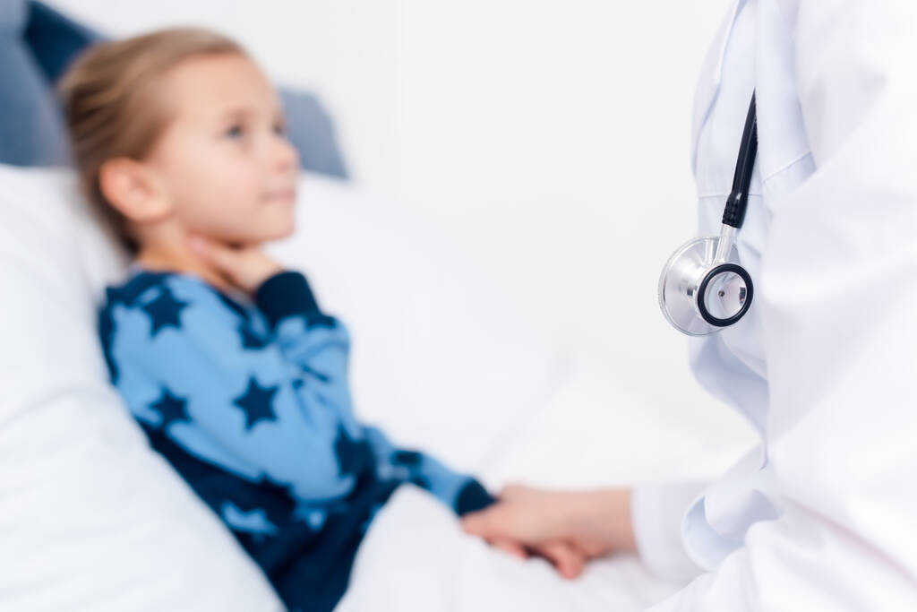 επιλεκτική εστίαση του γιατρού σε λευκό παλτό κοντά σε άρρωστο παιδί - Φωτογραφία, εικόνα