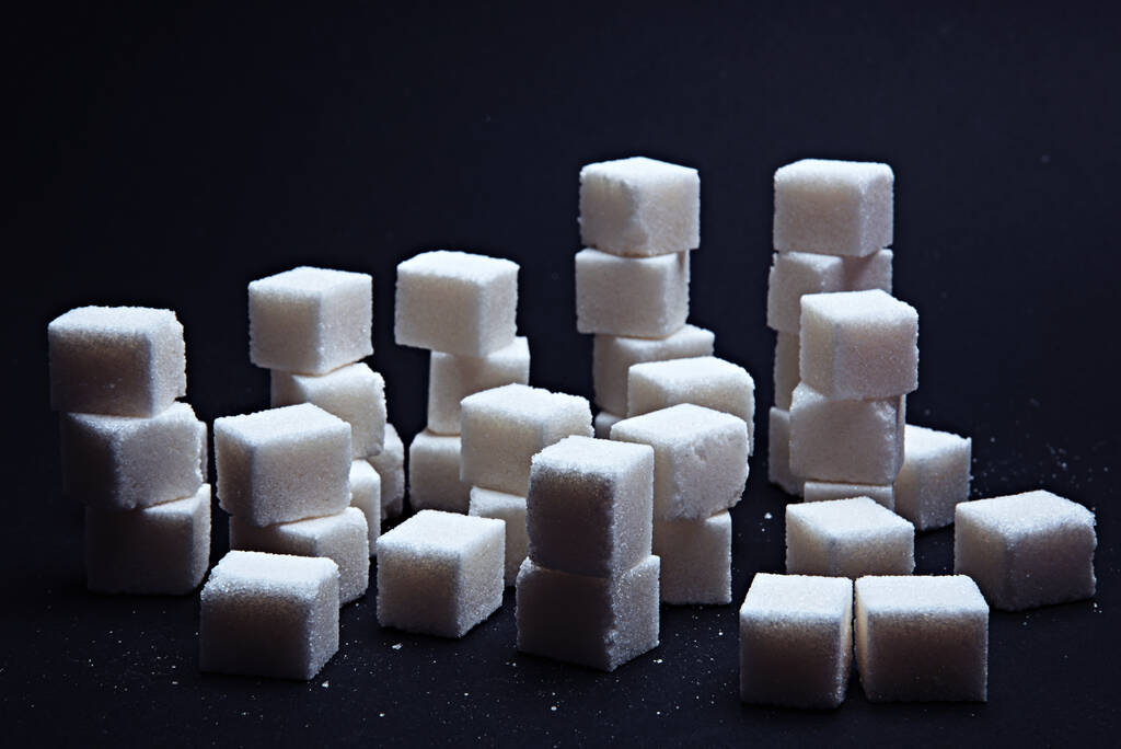 Pile of sugar cubes on a black background. - Photo, Image