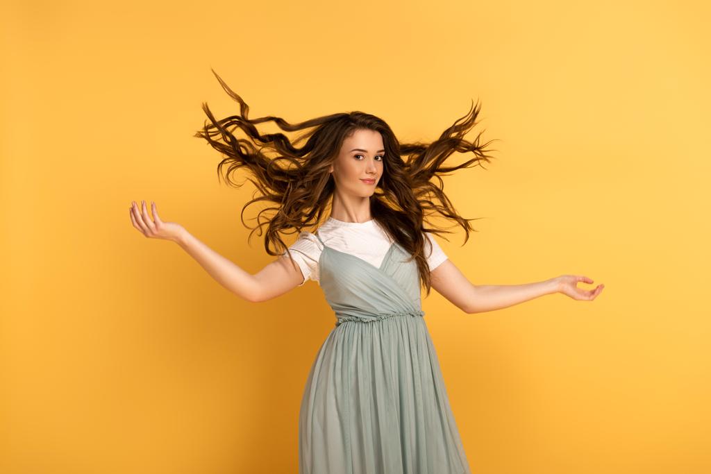 smiling young spring woman with long hair on yellow - Photo, Image