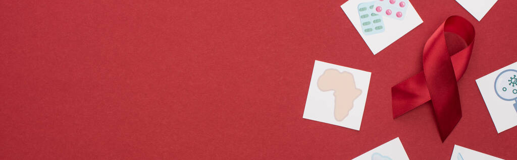vista superior de las tarjetas de papel y cinta roja de las ayudas de la conciencia sobre fondo rojo, tiro panorámico
 - Foto, imagen