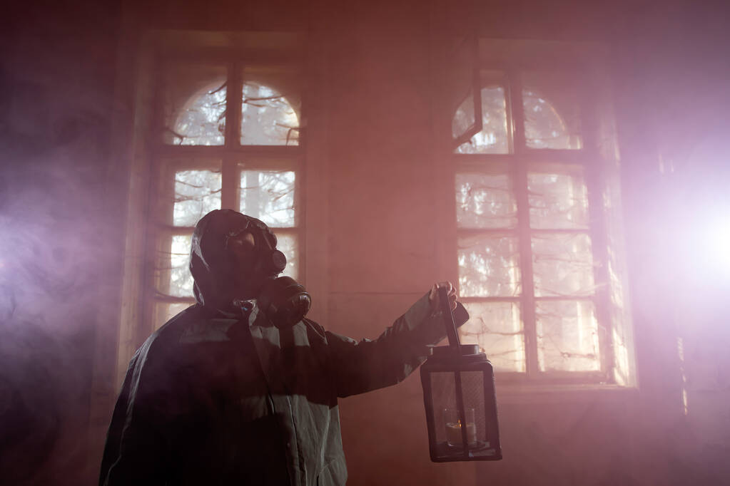 Superviviente post apocalíptico con máscara de gas en un edificio en ruinas. Desastre ambiental, concepto de armagedón. - Foto, imagen