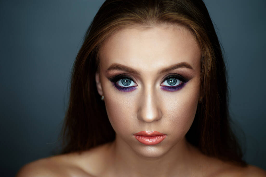 Portrait of a young woman with beautiful evening make-up on a dark background - Photo, Image