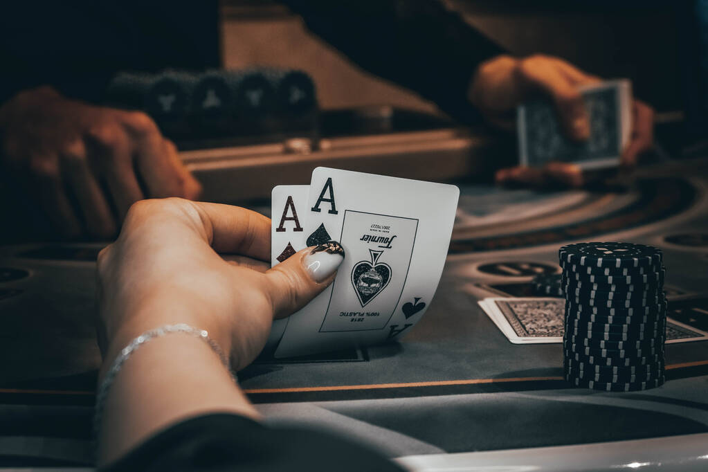 Jakaja tai krupieeri sekoittaa pokerikortteja kasinolla taustalla pöytä, sirut,. Käsite pokeripeli, peli liiketoimintaa
. - Valokuva, kuva