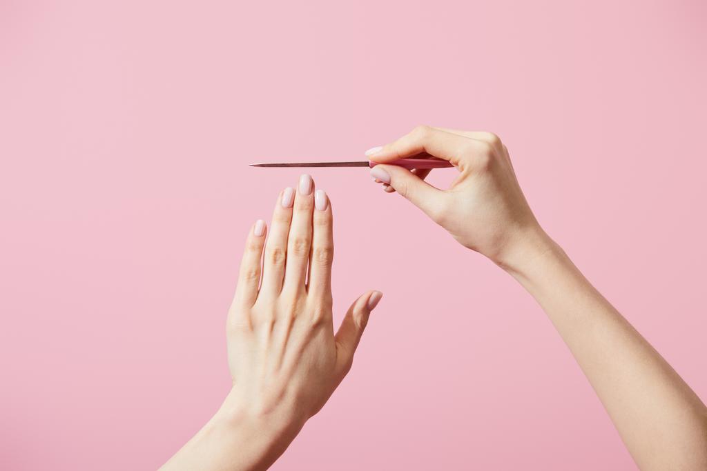 Vista cortada de mulher com arquivo de unhas isolado em rosa
 - Foto, Imagem