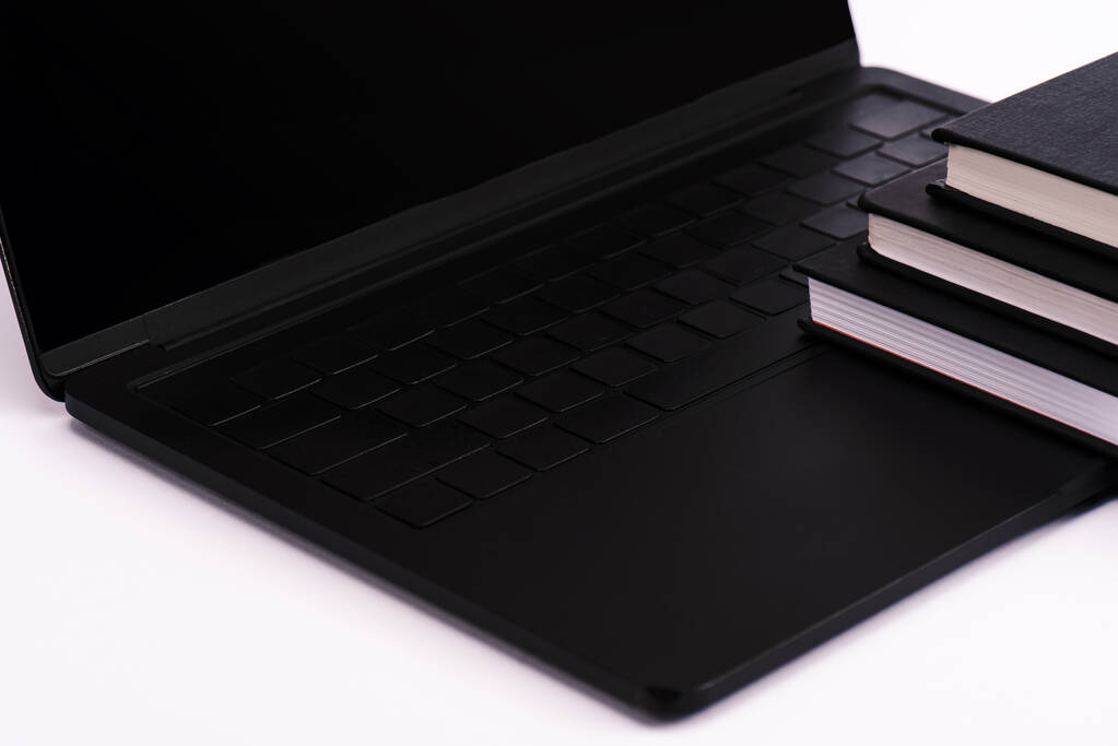 черные ноутбуки рядом с современным ноутбуком на белом
  - Фото, изображение