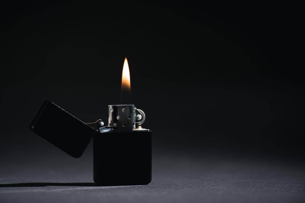 encendedor con fuego ardiente en negro con espacio de copia
  - Foto, Imagen