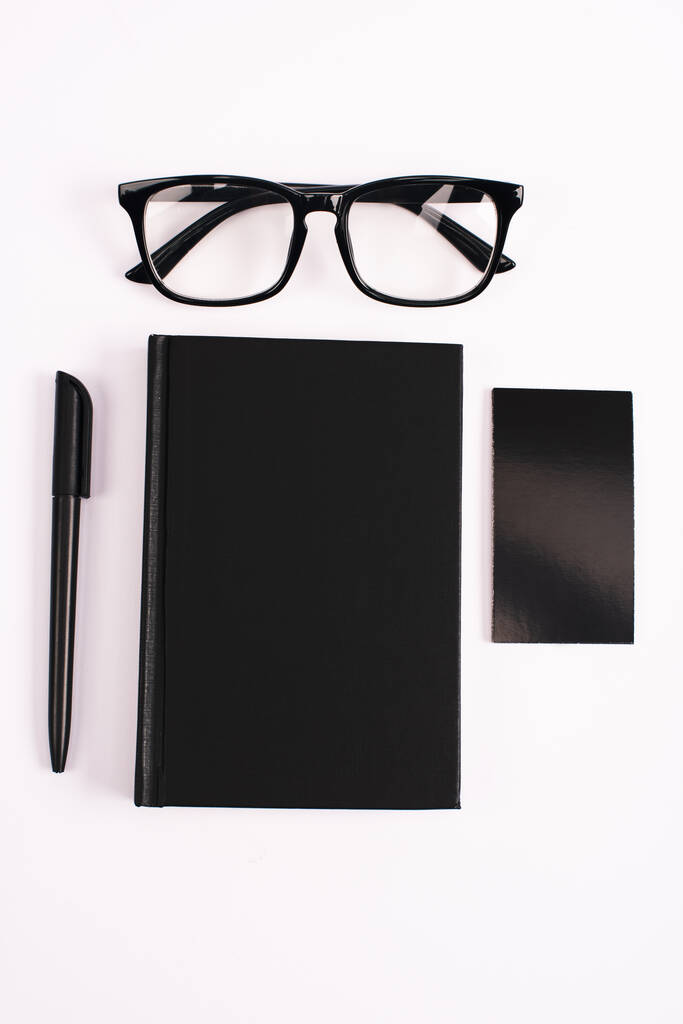 beyaz üzerine izole edilmiş gözlük, not defteri, kalem ve boş kart üst görünümü  - Fotoğraf, Görsel