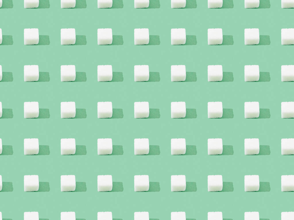 bovenaanzicht van klontersuiker op groen, naadloos achtergrondpatroon - Foto, afbeelding