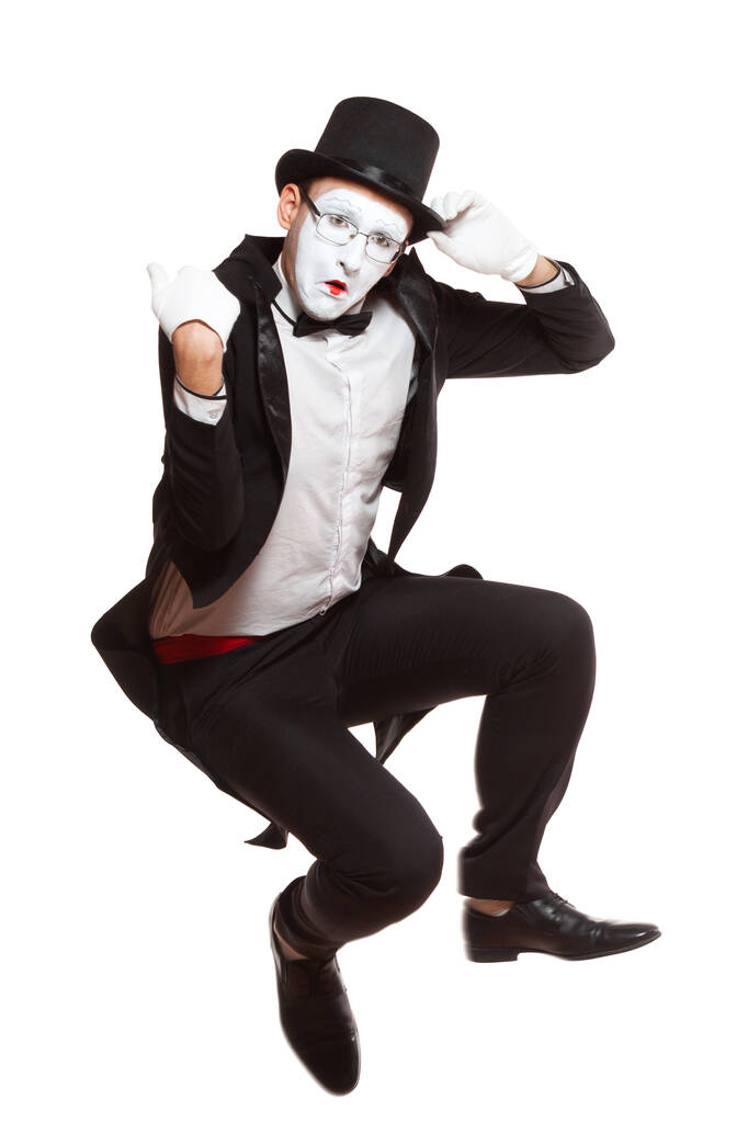 Egy férfi pantomim művész portréja, fehér háttérrel. Szimbóluma kellemetlenül meglepett, ideges, elesett, guggoló, szomorú - Fotó, kép