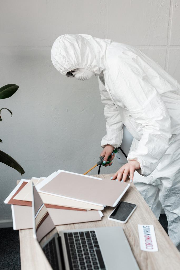 person in white hazmat suit, respirator and goggles disinfecting workplace in office, coronavirus concept - Photo, Image