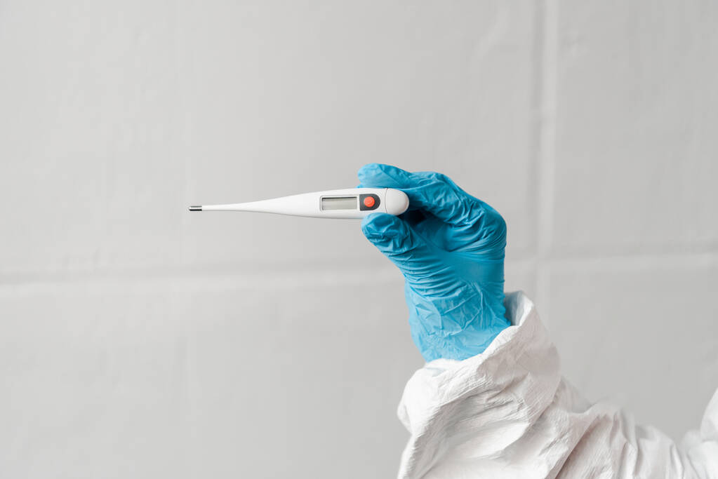 περικοπή άποψη του προσώπου στο γάντι λατέξ κρατώντας θερμόμετρο, έννοια coronavirus - Φωτογραφία, εικόνα