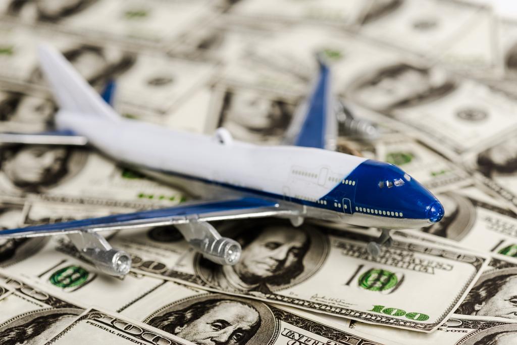 飛行機モデルの選択的焦点はドル紙幣、コロナウイルス経済危機の概念 - 写真・画像