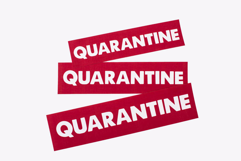 bovenaanzicht van rode kaarten met quarantaine letters geïsoleerd op wit  - Foto, afbeelding