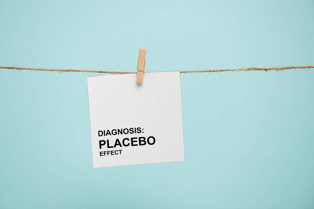 Kártya diagnózissal placebo hatás felirattal a kötélre, kék alapon izolált tűvel  - Fotó, kép