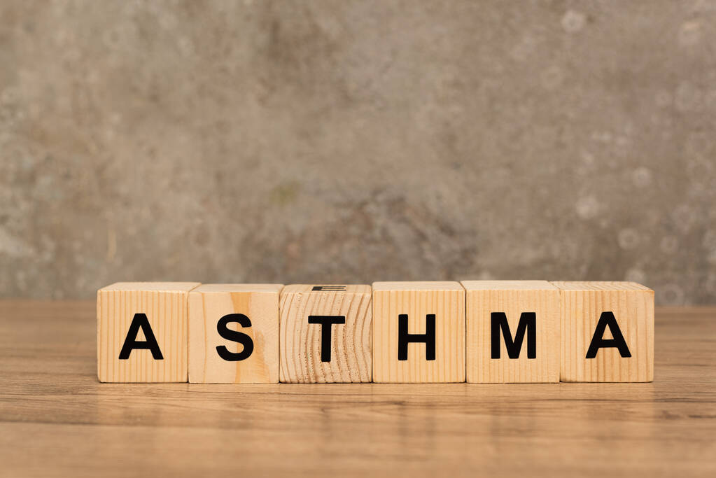Drewniane kostki z napisem astmy na drewnianym stole na szarym tle - Zdjęcie, obraz