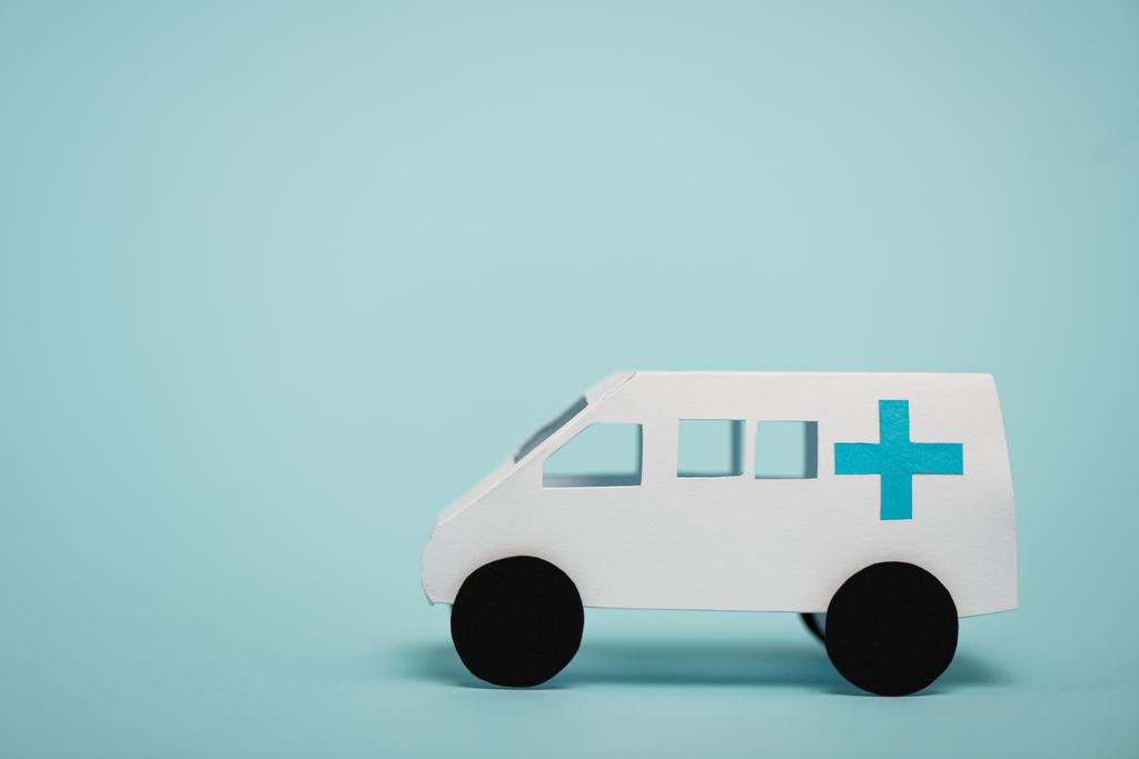 Speelgoedauto voor noodgevallen op blauw oppervlak met kopieerruimte - Foto, afbeelding