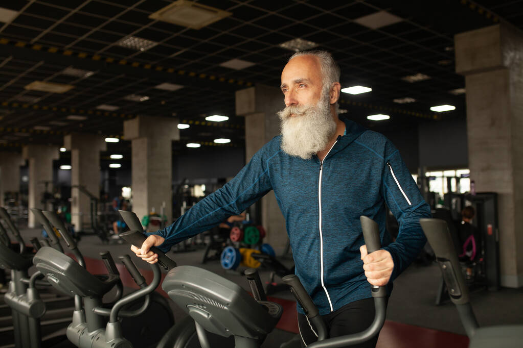 Starší muž na běžícím stroji v tělocvičně - Fotografie, Obrázek