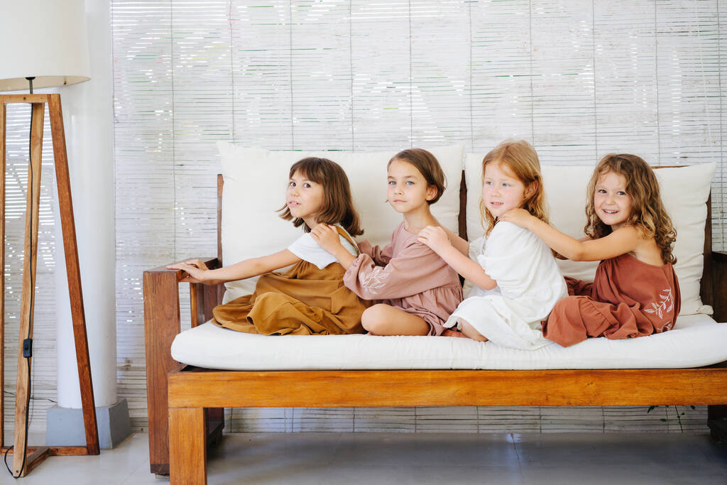 ４人の女の子がソファーの上で座ってる - 写真・画像