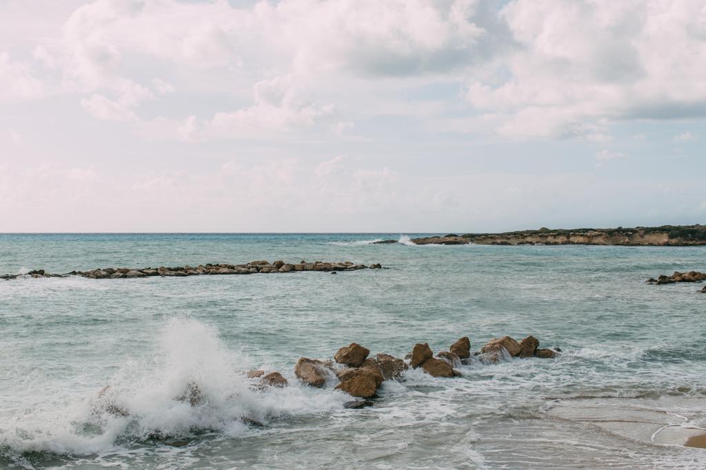 βράχια κοντά στη Μεσόγειο θάλασσα ενάντια στο γαλάζιο του ουρανού με σύννεφα  - Φωτογραφία, εικόνα