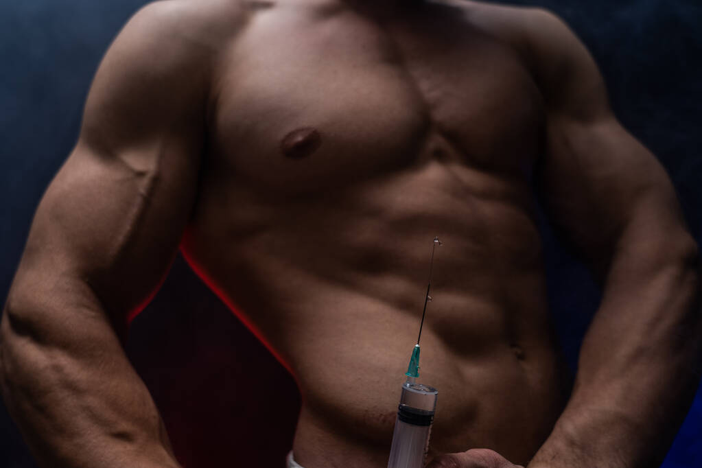 Culturista che tiene una siringa grande con iniezione. concetto di steroide nello sport e dipendenza
  - Foto, immagini