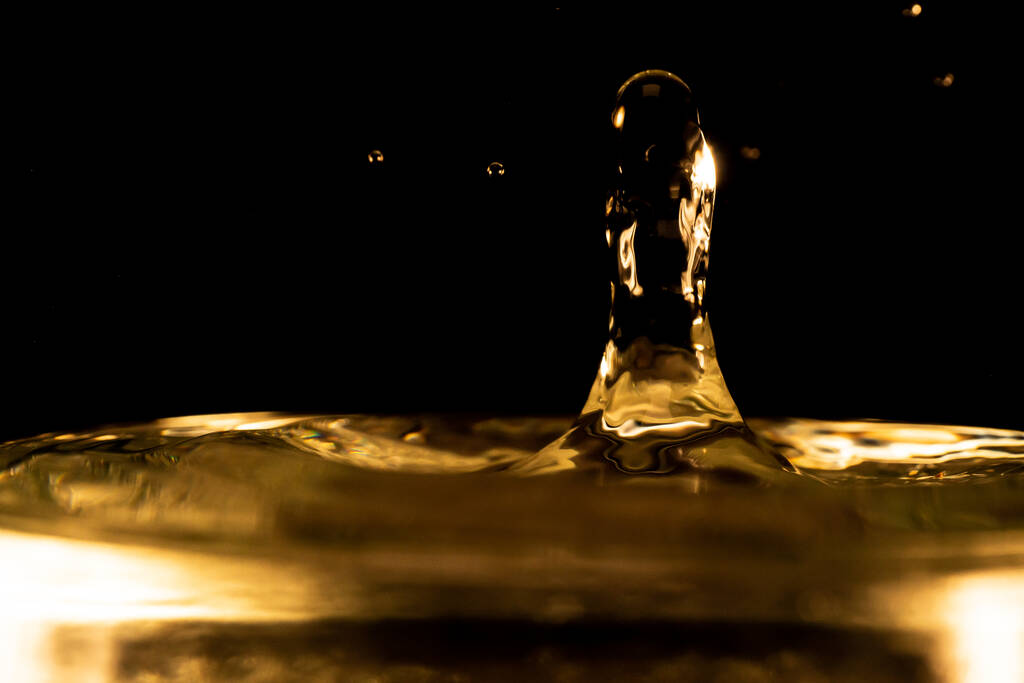 Víz fröccsenés, arany víz fröccsenés elszigetelt fekete alapon, víz - Fotó, kép