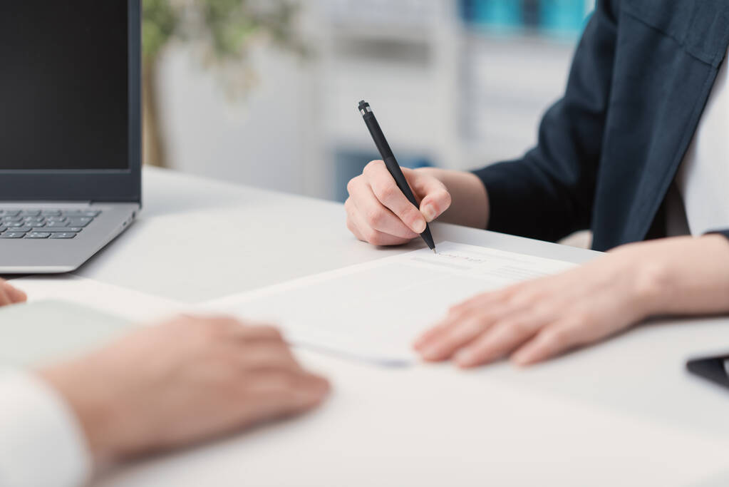 Reunión de empresarios en la oficina, una mujer está firmando un contrato: acuerdo y concepto de contratación
 - Foto, Imagen