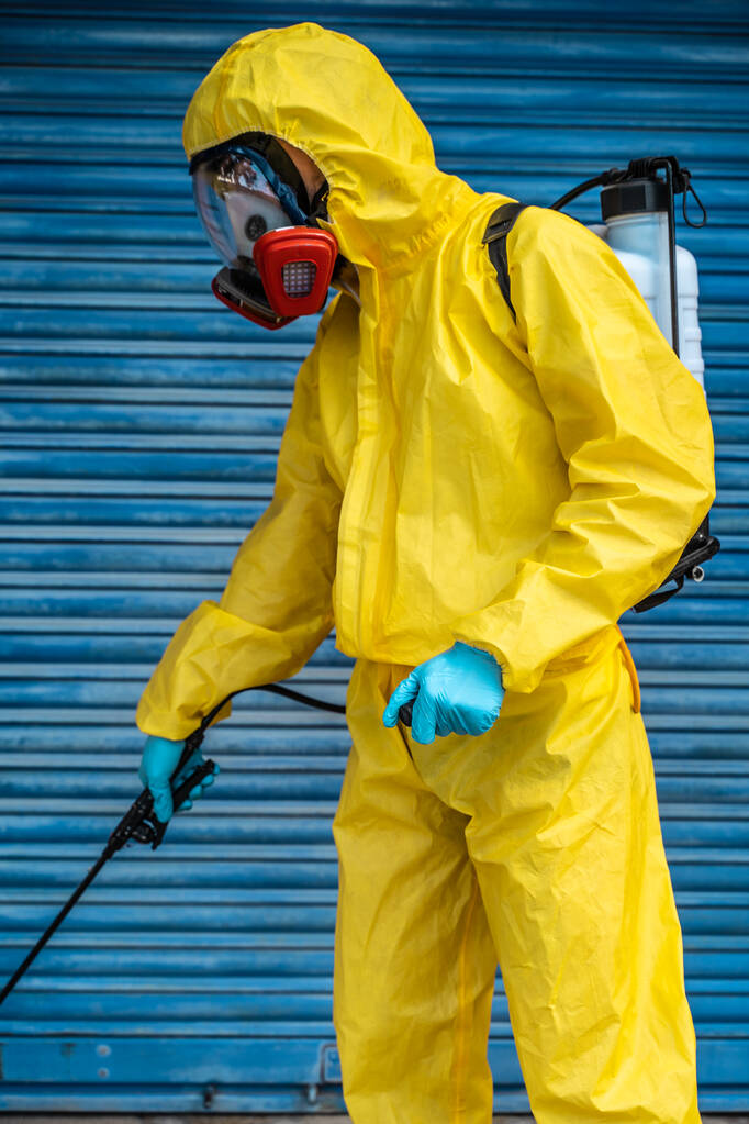 Coronavirus. Ein Sanitärarbeiter trägt eine Maske und reinigt die Straßen. Sterilisieren städtischen dekontaminieren Stadt. Desinfektion gegen das Coronavirus. Anzugschutz.  - Foto, Bild