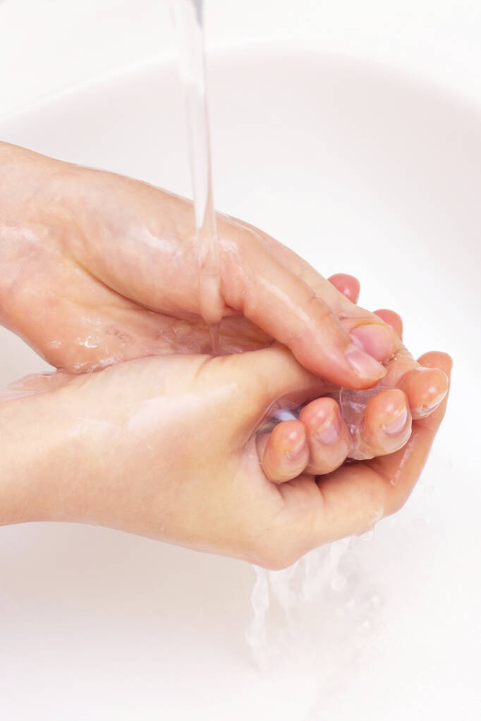 Facet myje ręce. ręce w pianie antybakteryjnego mydła. Ochrona przed bakteriami, koronawirusami. higiena rąk. umyj ręce wodą. wiele rąk. zdjęcie pionowe - Zdjęcie, obraz
