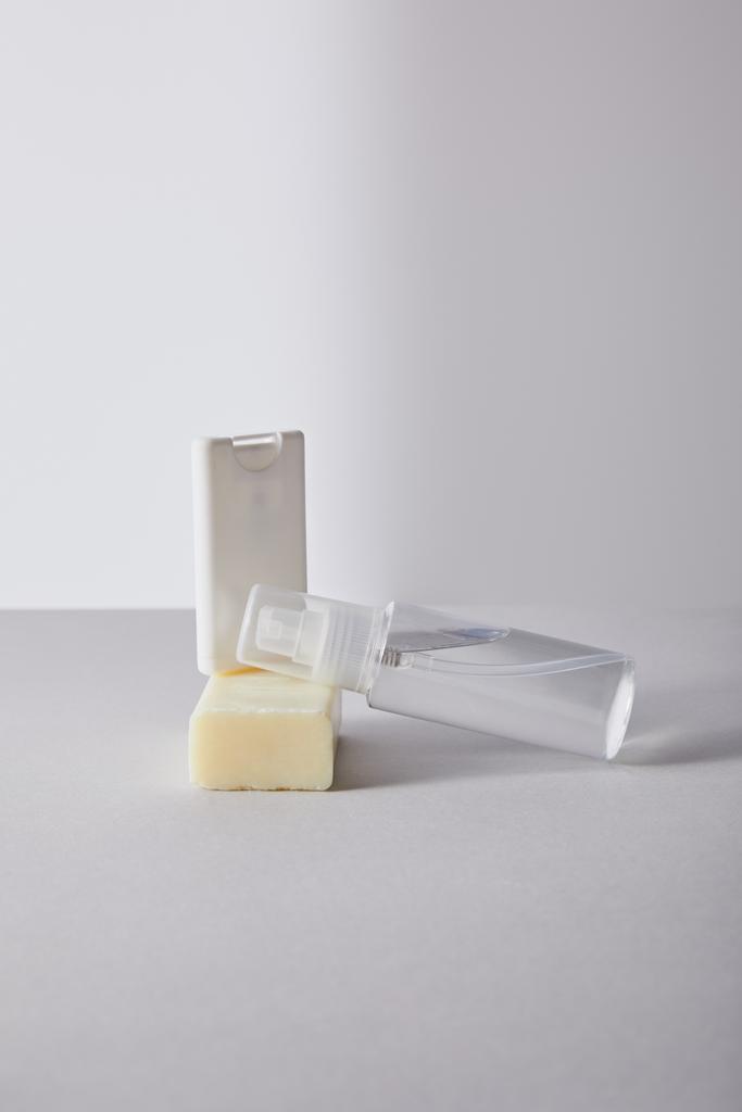 kézfertőtlenítő spray palackban és antibakteriális szappan fehér alapon - Fotó, kép