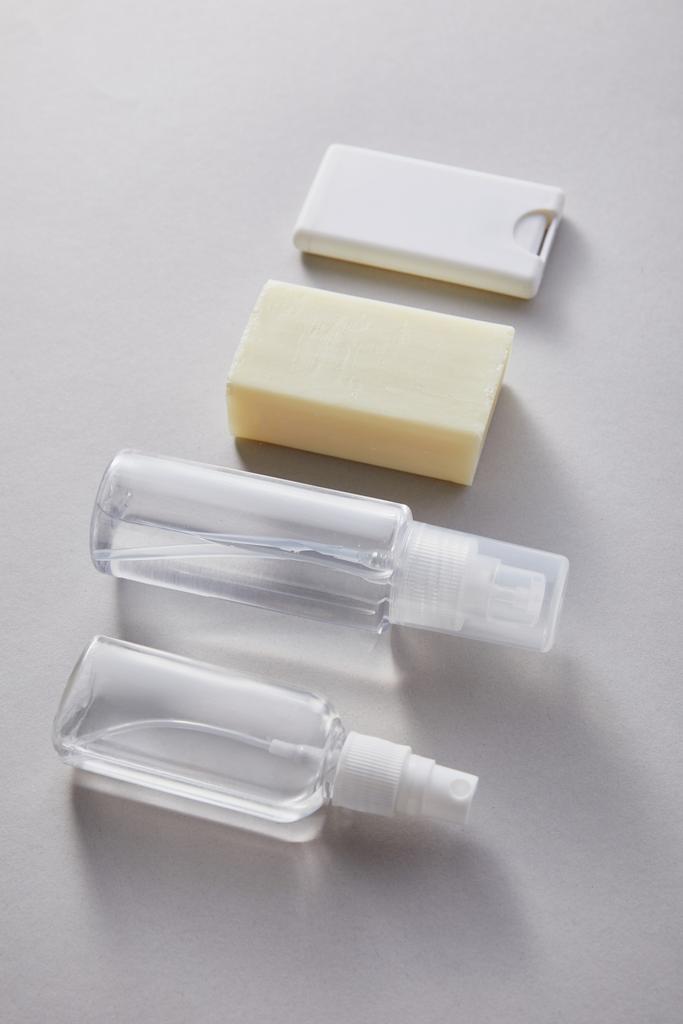 Плоский лежал с дезинфицирующим средством для рук в баллончиках с антибактериальным мылом на сером фоне
 - Фото, изображение