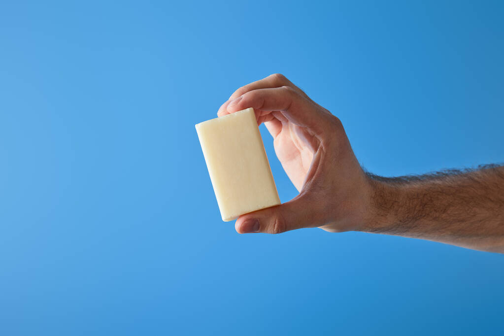 cropped view of man holding soap isolated on blue - Photo, Image