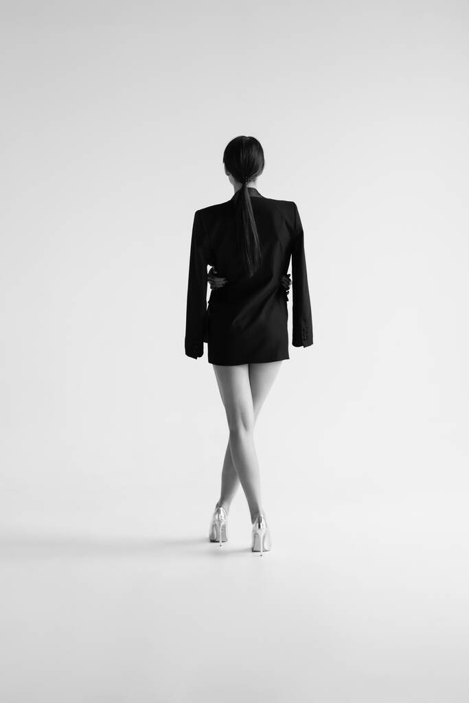 Back view of young woman wearing jacket on white background - Photo, Image