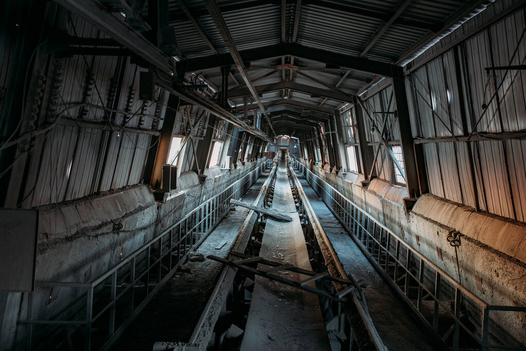 Abandoned cement and concrete factory. Old rusty conveyor in corridor. - Photo, Image