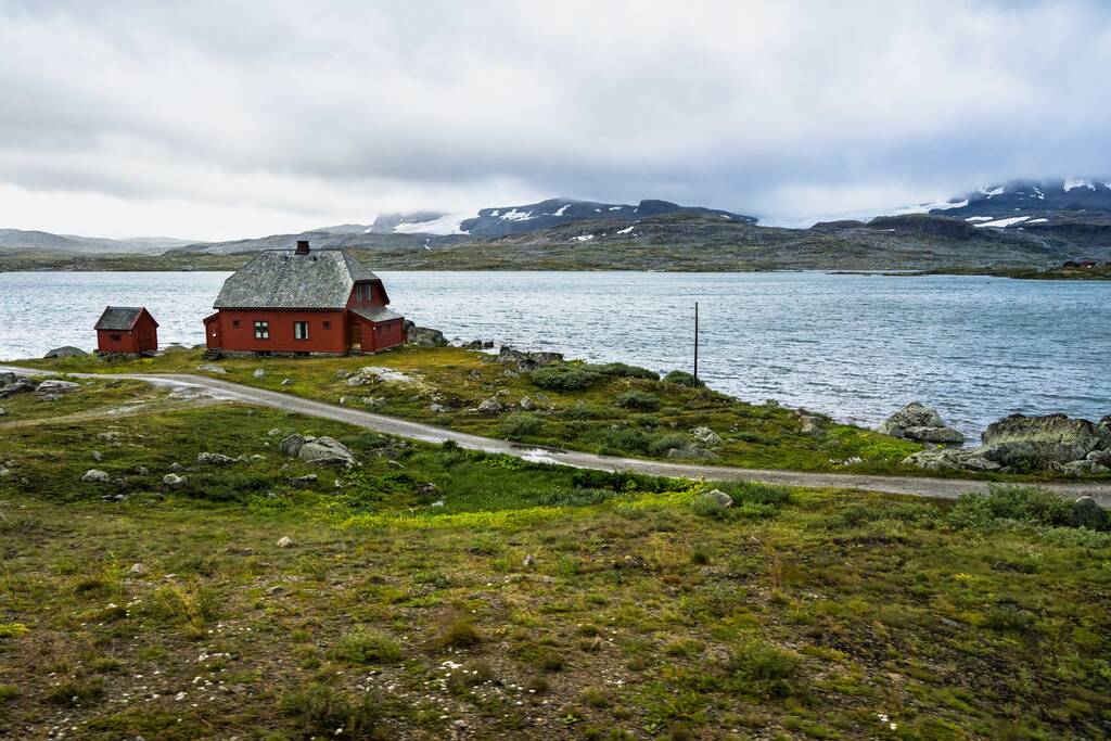 Ein abgelegenes Haus an einem See im Hardangervidda Nationalpark in der Nähe von Finse, Norwegen - Foto, Bild