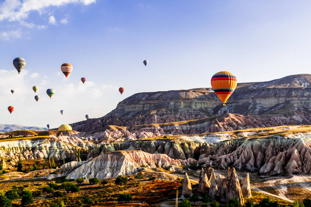 Горем / Невшехир, Турция - 27 сентября 2019 года: Красочные воздушные шары, летящие над долиной в Каппадокии, Анатолия, Турция. Вулканические горы в национальном парке Гореме
. - Фото, изображение