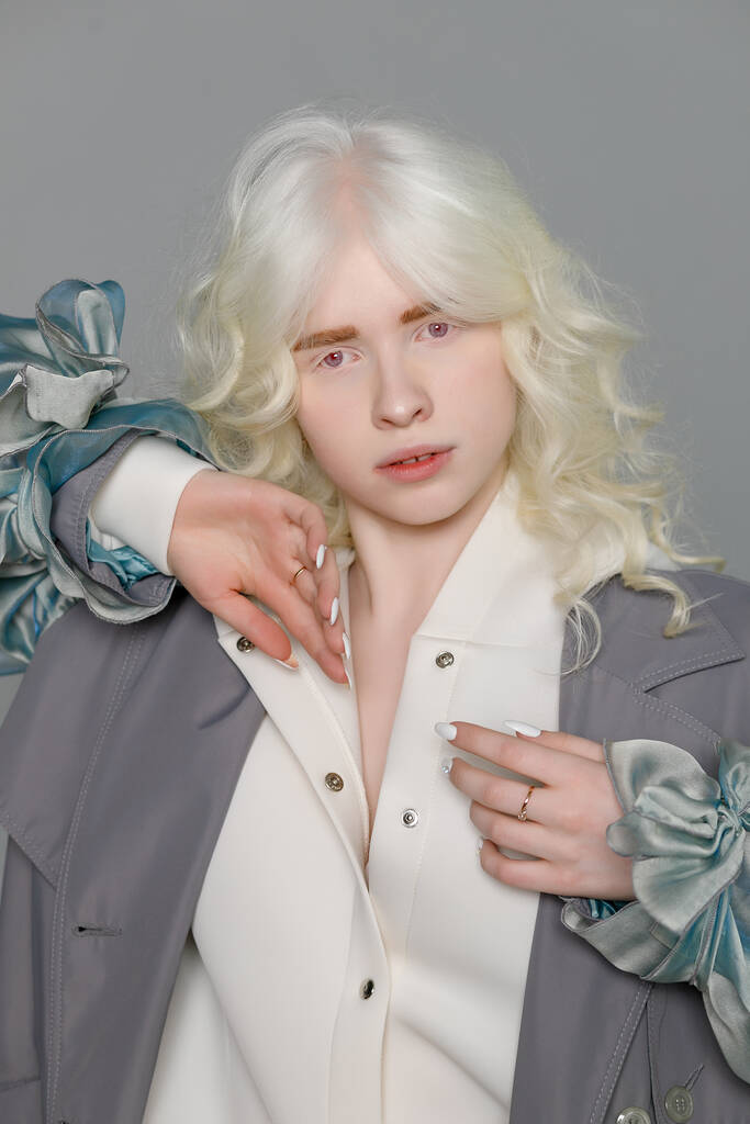 mooi albino meisje met witte huid, natuurlijke lippen en wit krullend haar dragen stijlvolle witte trui, close-up foto, kopieer ruimte, schoonheid, mode. Blond meisje - Foto, afbeelding