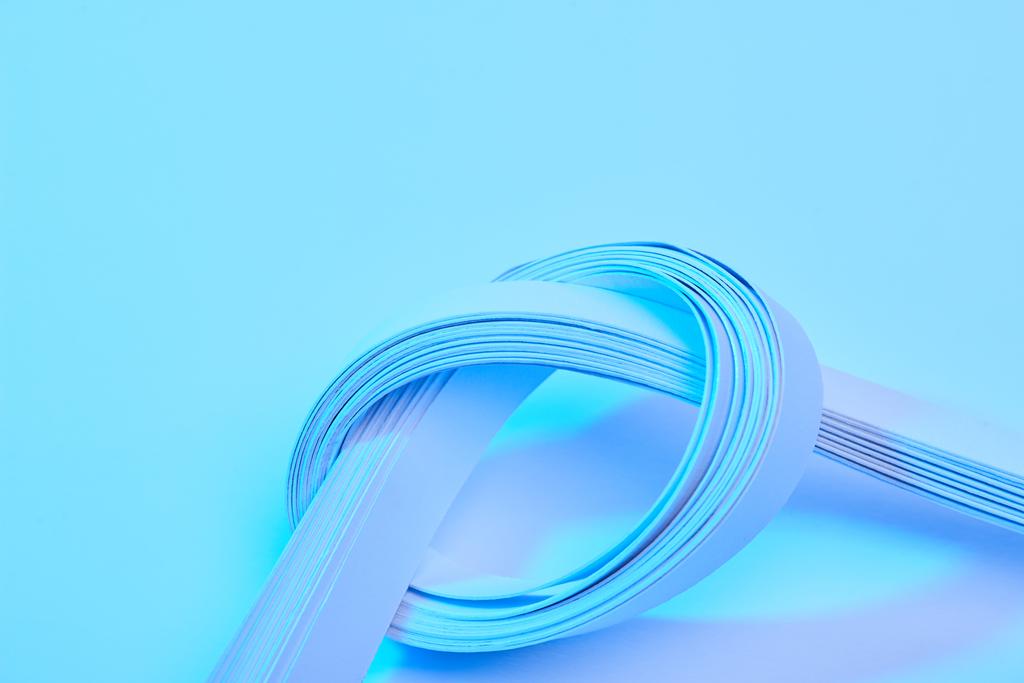 Neon mavi arkaplan üzerindeki kağıt şeritlerin görünümünü kapat - Fotoğraf, Görsel