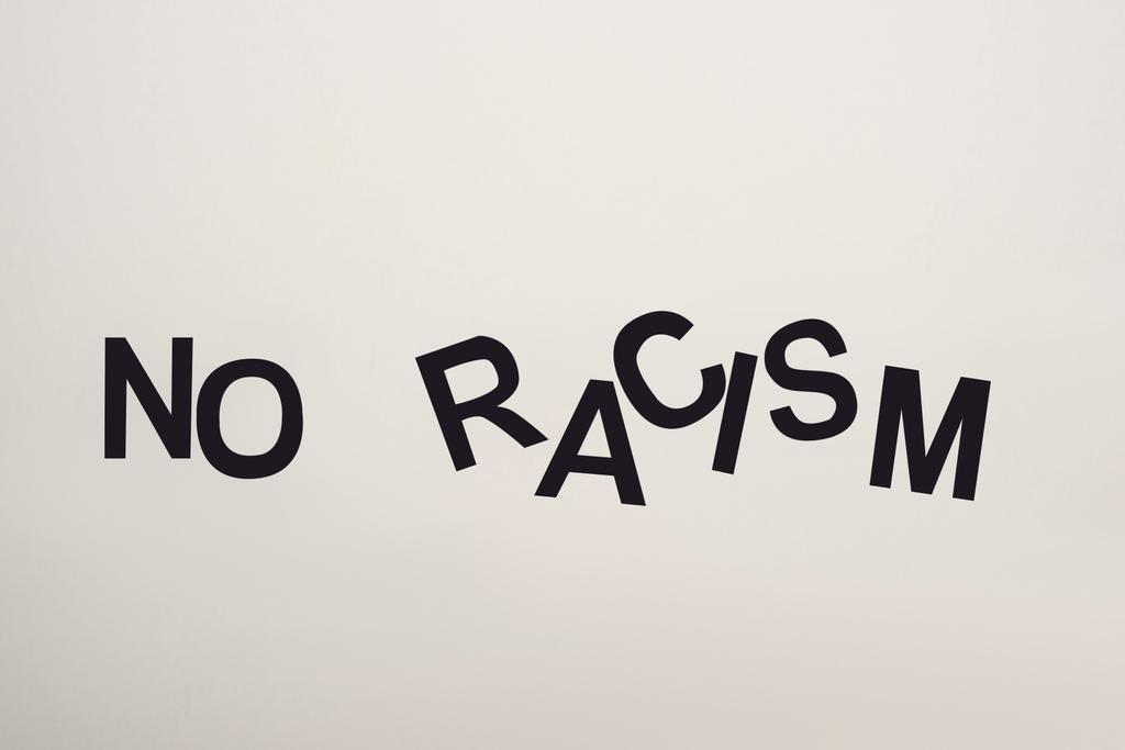 top view of black no racism lettering isolated on white - Photo, Image