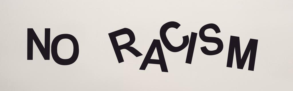 top view of black no racism lettering isolated on white, panoramic shot - Photo, Image