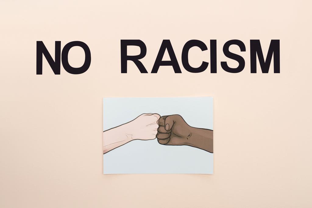 πάνω άποψη του μαύρου χωρίς ρατσισμό γράμματα και εικόνα με ζωγραφισμένα πολυεθνικά χέρια κάνει χτύπημα γροθιά σε μπεζ φόντο - Φωτογραφία, εικόνα