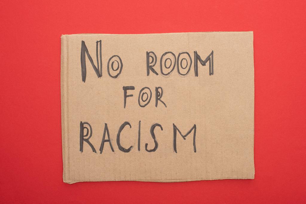 πάνω άποψη του χαρτονιού πλακάτ χωρίς χώρο για ρατσισμό γράμματα σε κόκκινο φόντο - Φωτογραφία, εικόνα