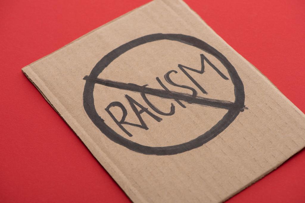 cartel de cartón con signo de racismo stop sobre fondo rojo
 - Foto, imagen