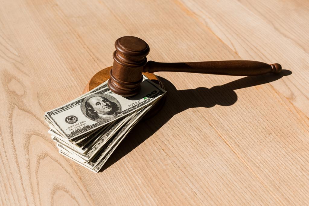 wooden gavel on dollar banknotes and textured table  - Photo, Image