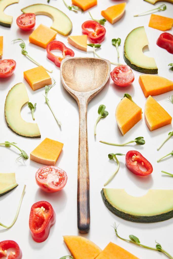 Vue grand angle de la spatule avec microgreens, légumes coupés et tranches d'avocat mûres sur fond blanc
 - Photo, image