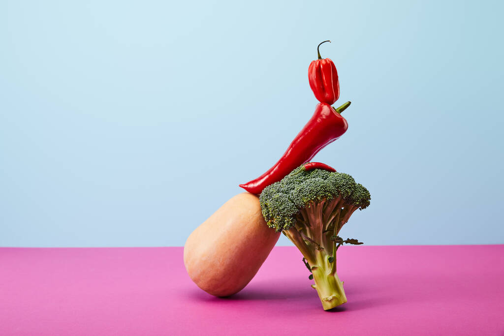 горячий хабанеро и перец чили поверх брокколи и тыквы на голубом и розовом
 - Фото, изображение
