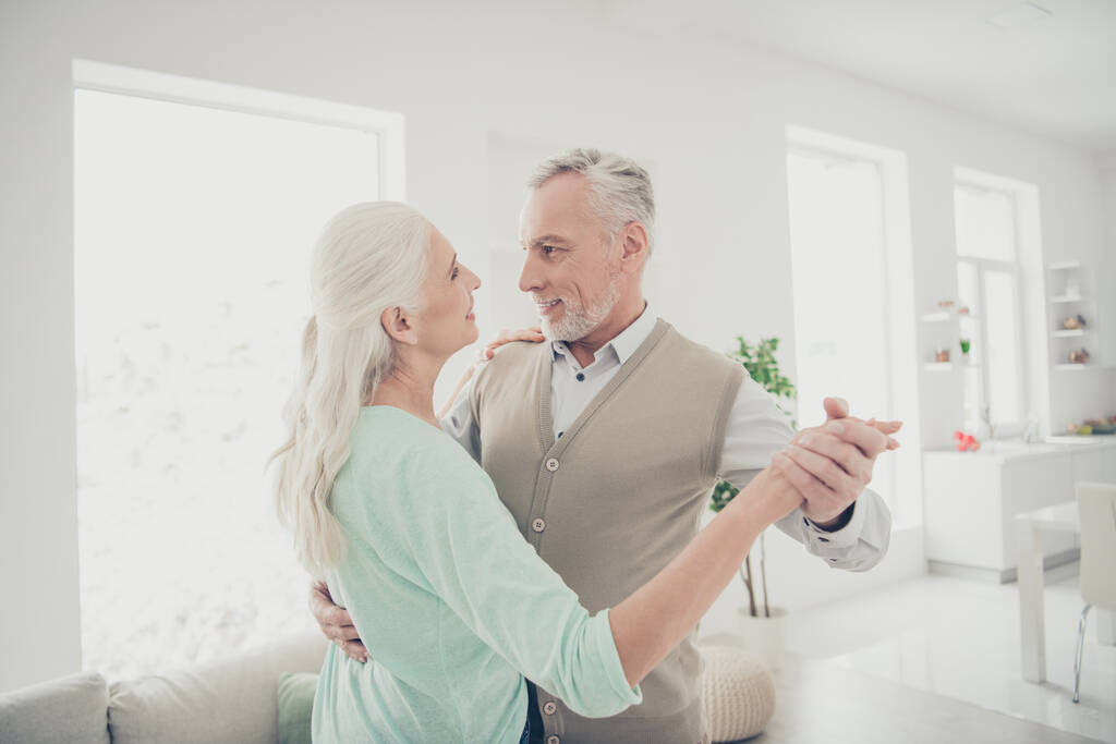 Retrato de personas casadas encantadoras cogidas de la mano moviéndose en casa apartamento vestido de color verde azulado jerséis marrones
 - Foto, imagen